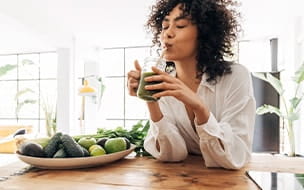 Young woman drinking a green smoothie